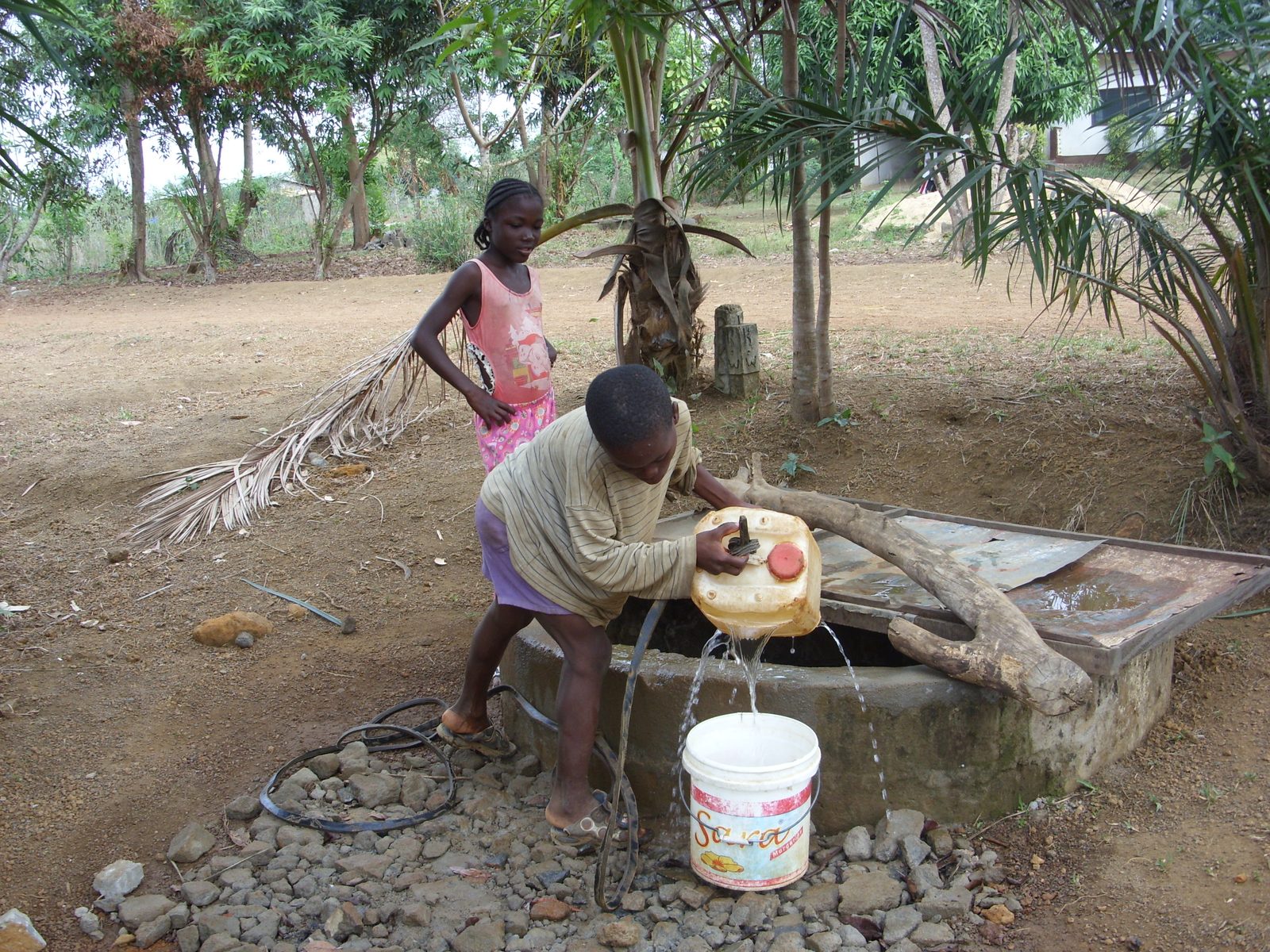 Children collecting water from an open well near Monrovia