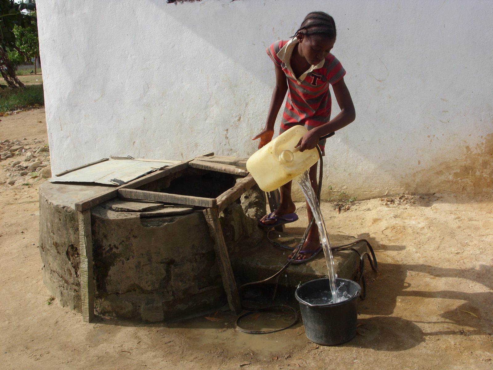 Young girl fetching water from a well in Liberia